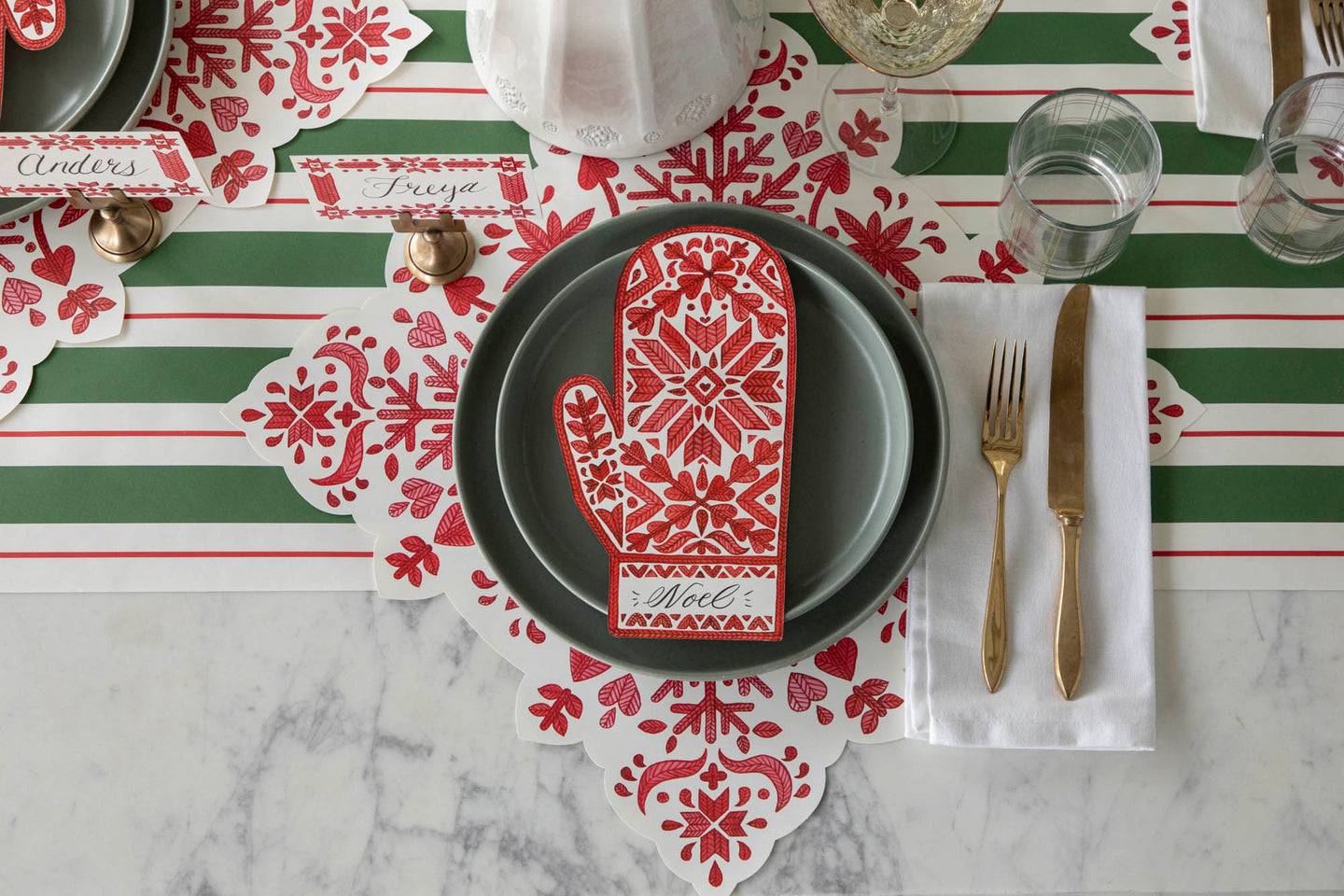 An elegant table setting featuring the Die-cut Fair Isle Snowflake Placemat, Fair Isle Mitten Table Accent and Green & Red Awning Stripe Runner.