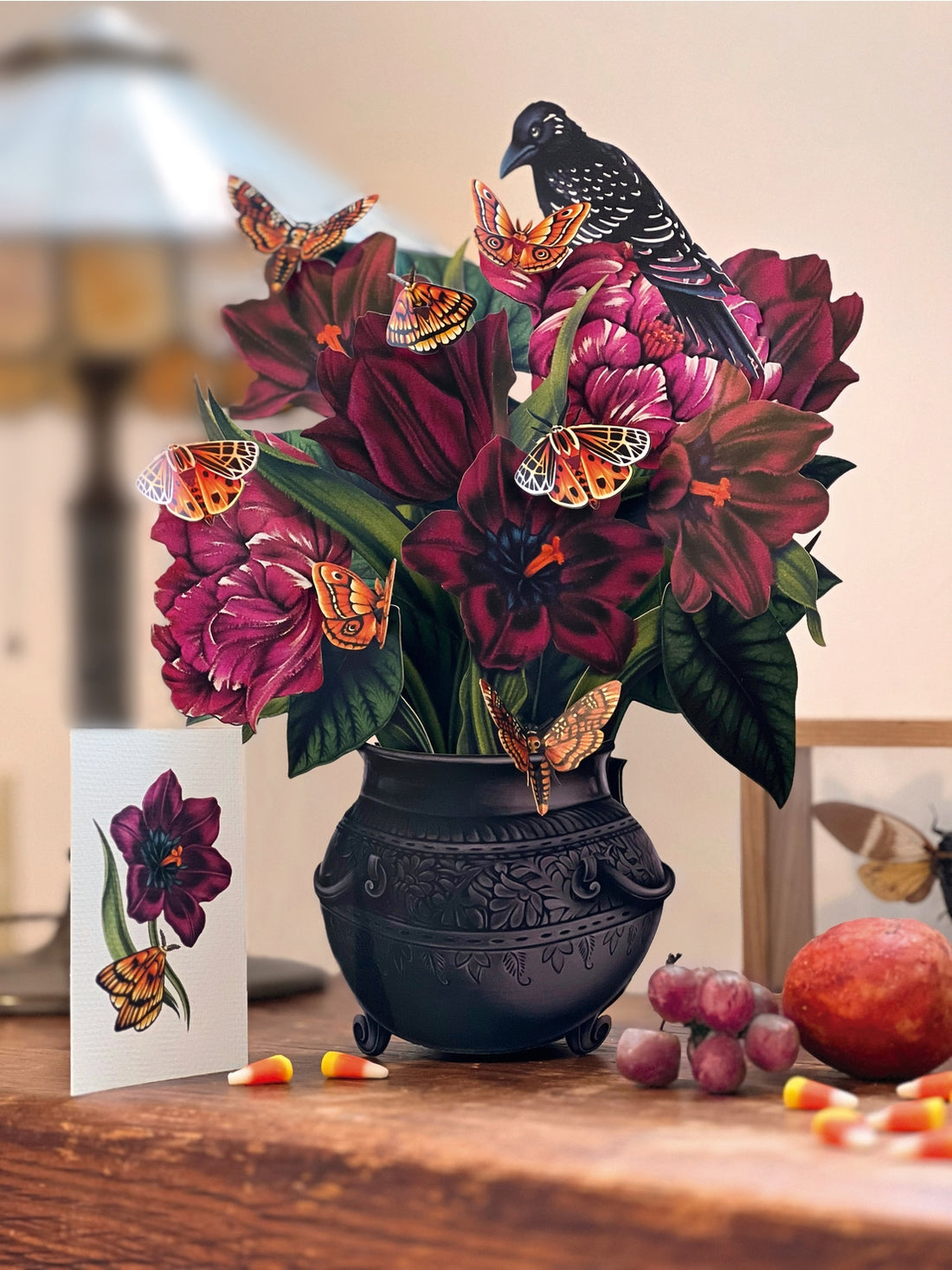 Paper decorative vase with flowers and butterflies on a wooden surface. 