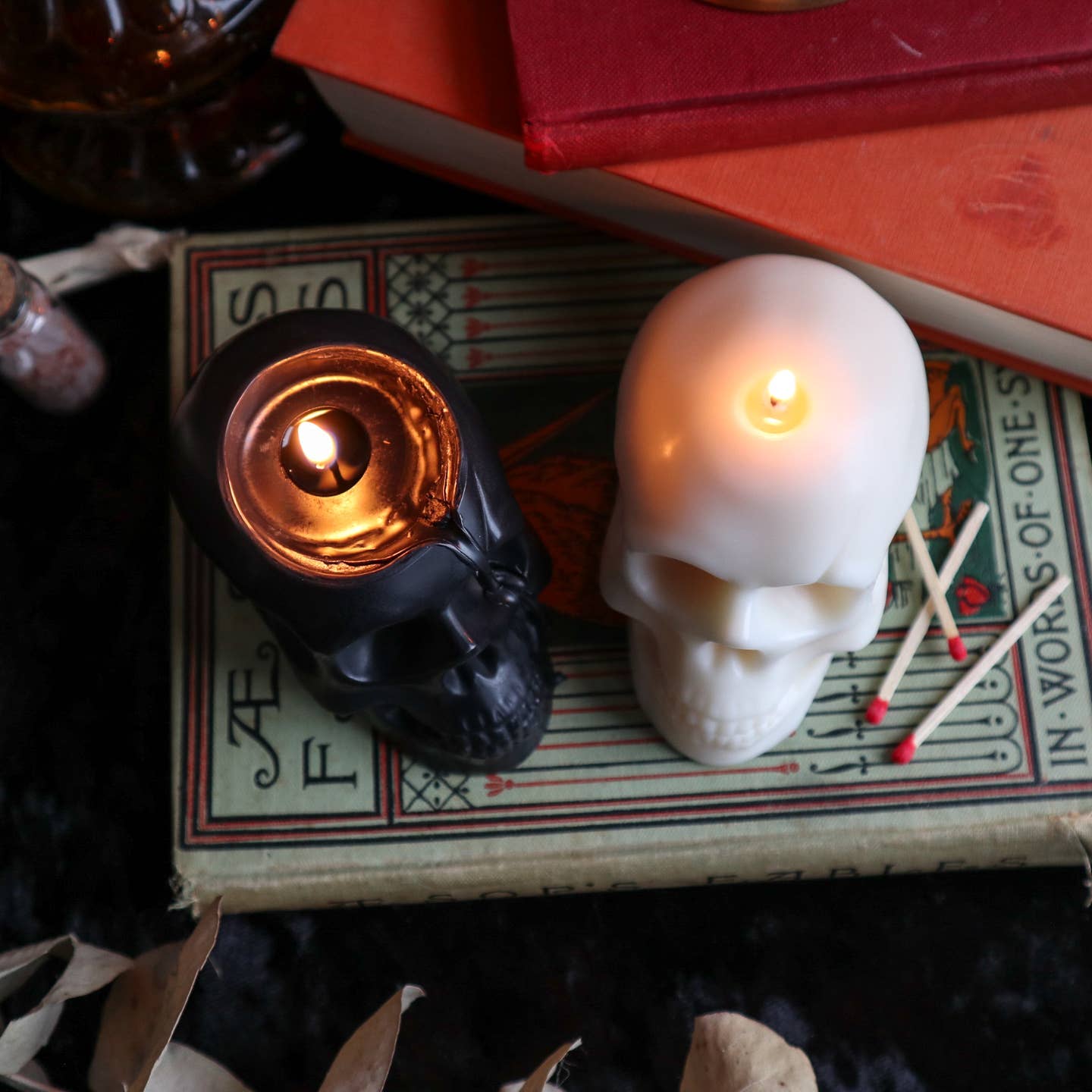 Black and cream skull shaped candle burning. 