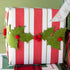Christmas gift wrapped in red and white striped paper with holly decorations.