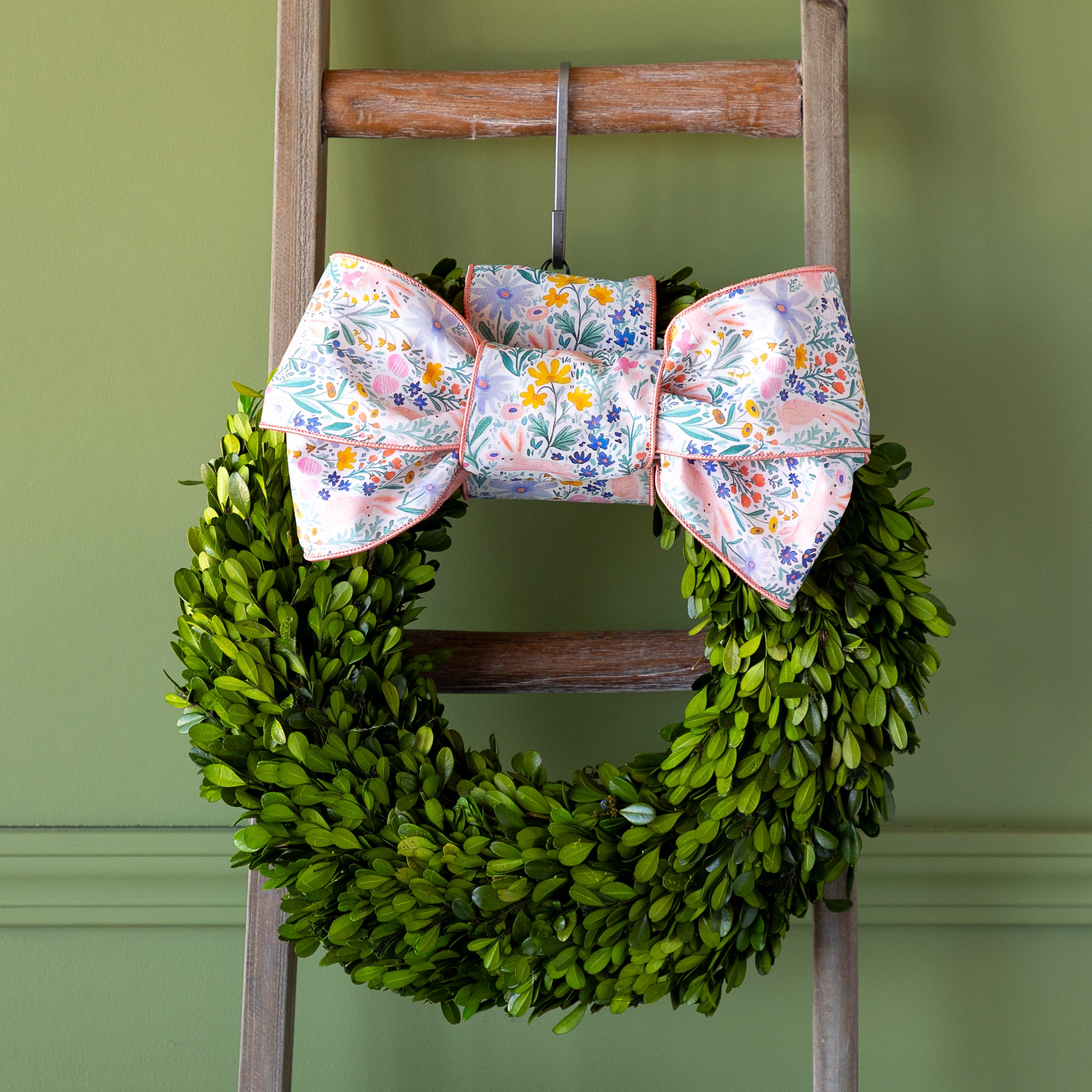 Poplin Watercolor Floral Bunny Ribbon tied in a bow atop a boxwood round wreath.