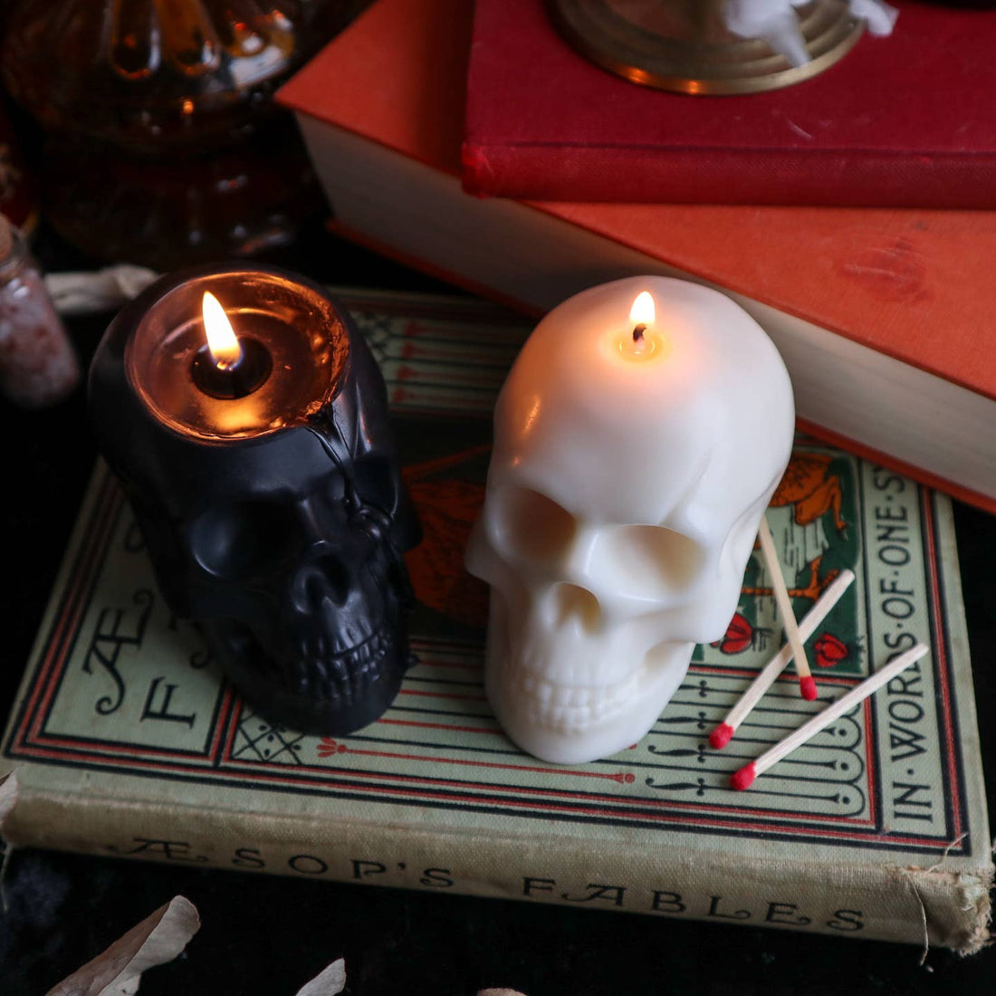 Black and cream skull shaped candle burning. 
