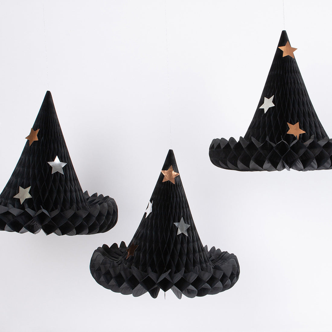 Three black honeycomb witch hats with star decorations on a white background