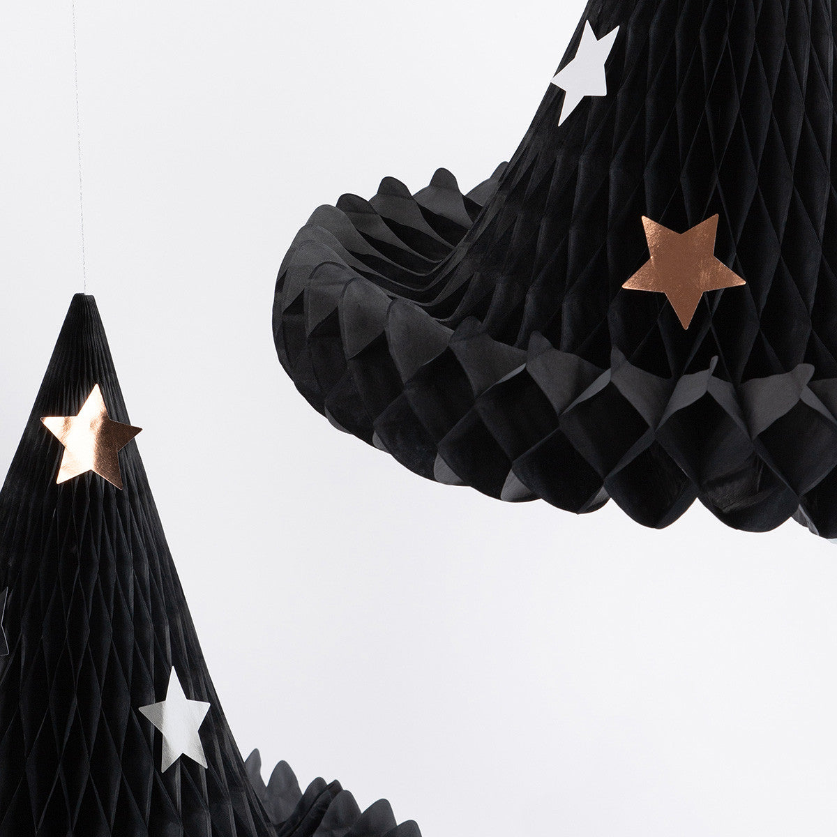 Black honeycomb decorations with star accents on a white background