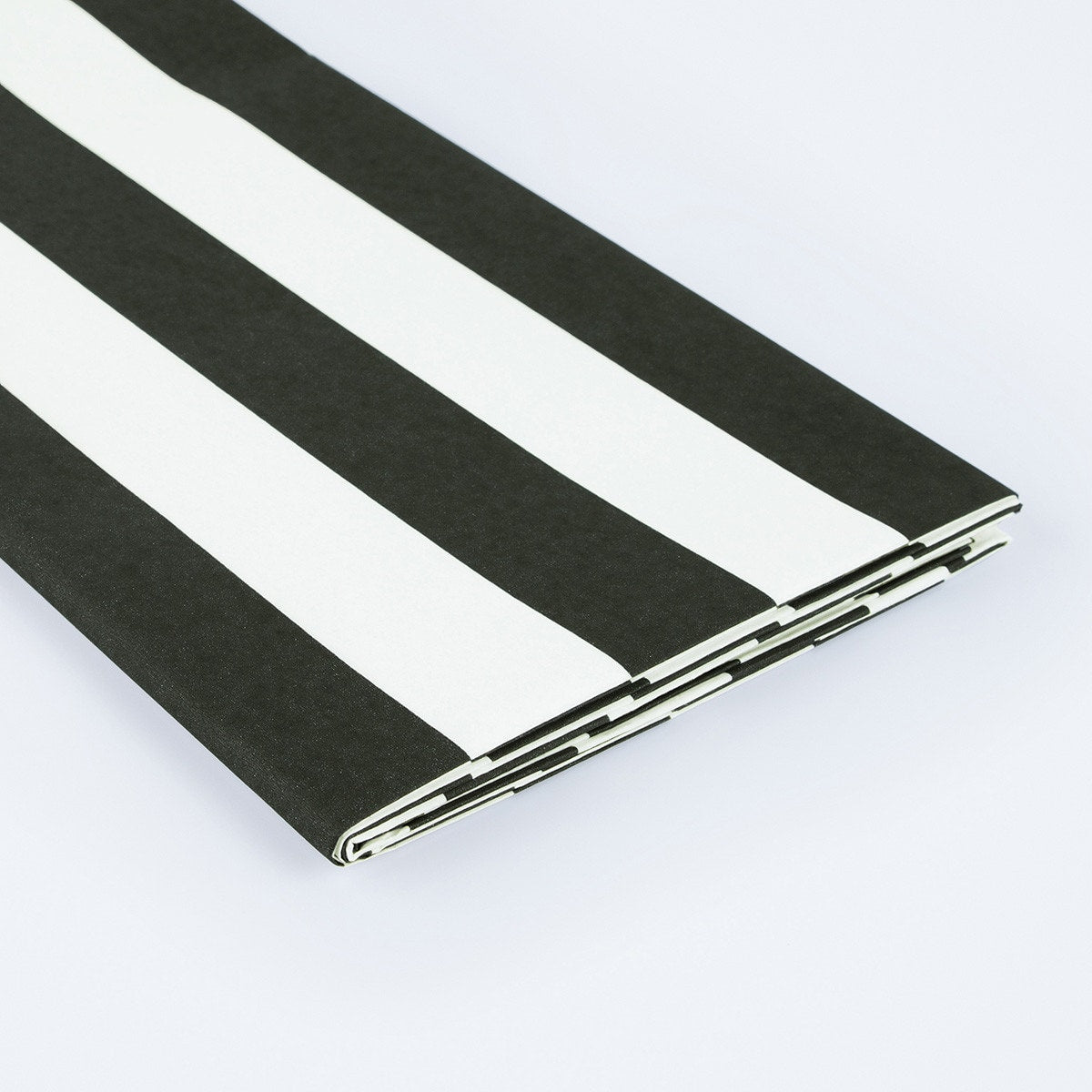 Black and white striped paper tablecloth on a light gray background.