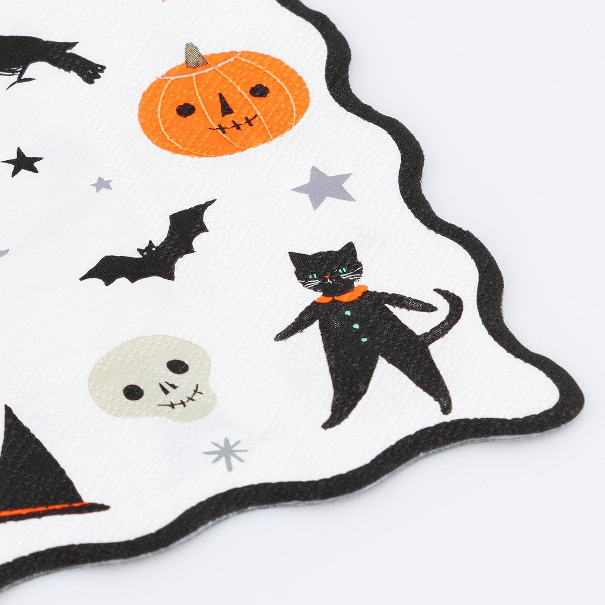 Halloween-themed paper napkin illustrated with ghosts, pumpkins, cats, and stars on a white background.