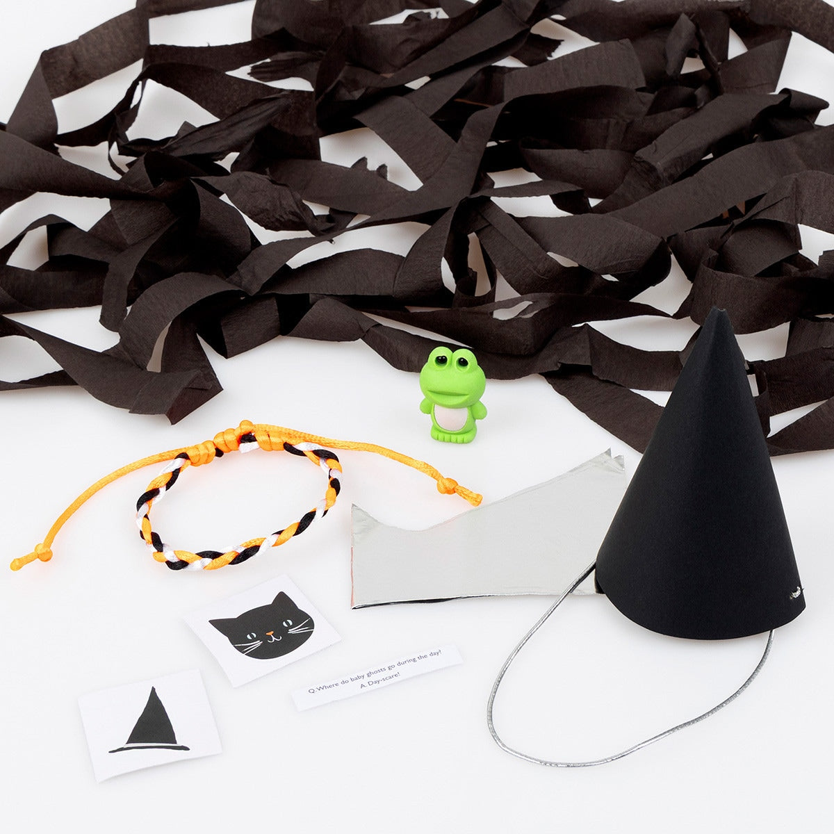 Gifts inside surprise hats, a small green frog, a friendship bracelet of orange, black and white and 2 stickers one a cat and one a witch hat.  