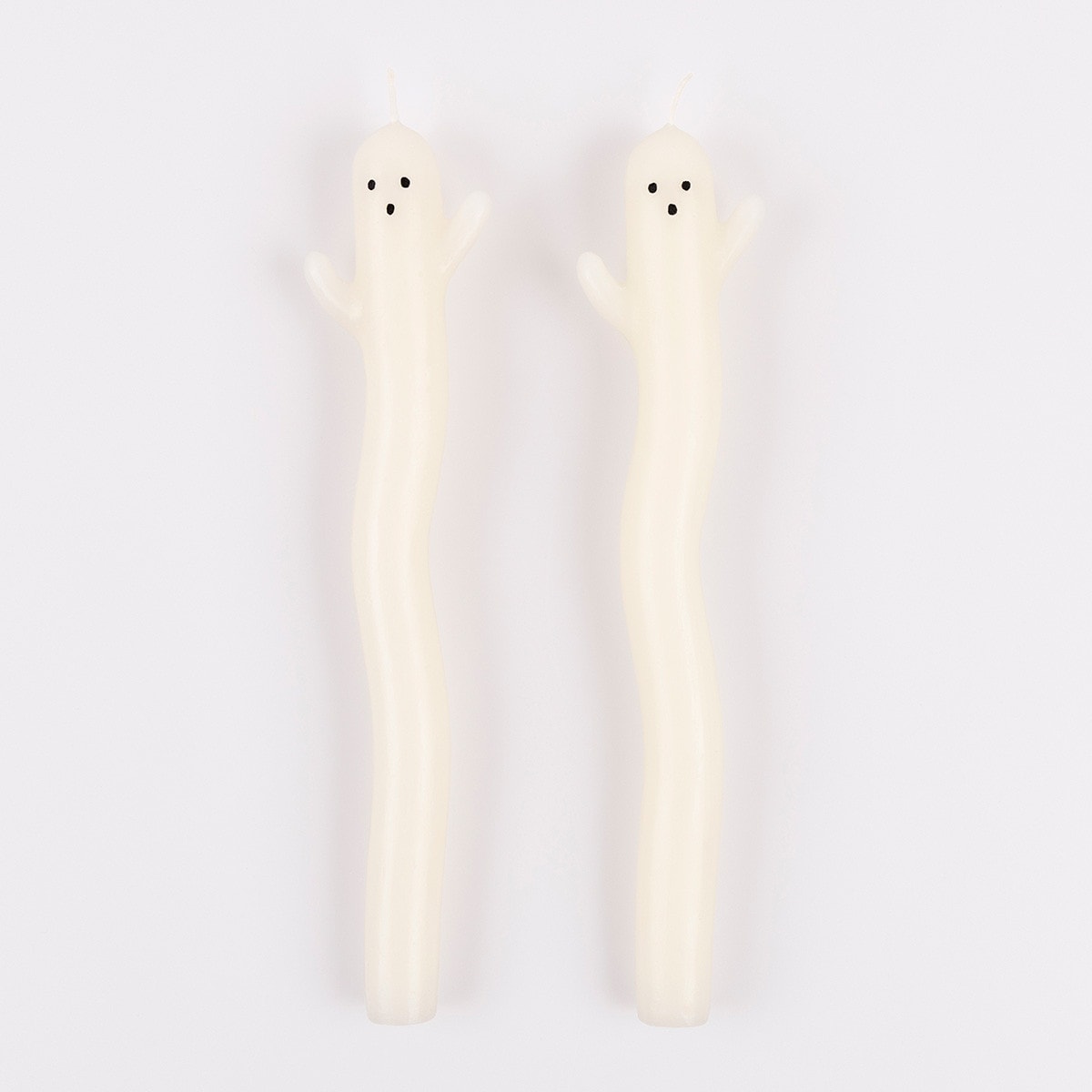 Two ghost-shaped candles on a white background