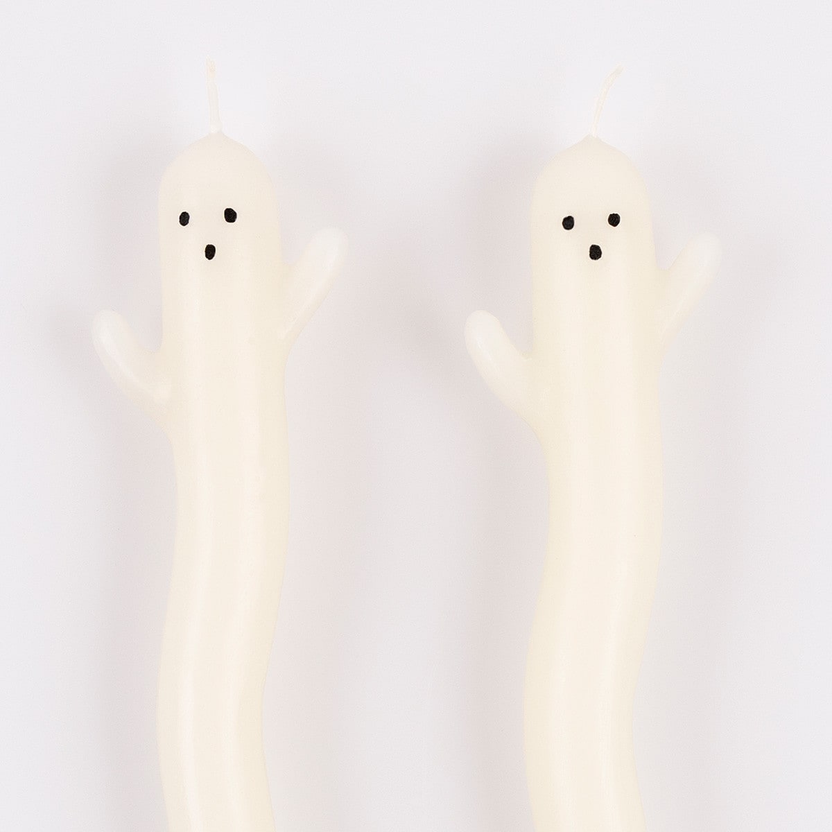 Two ghost-shaped candles on a white background