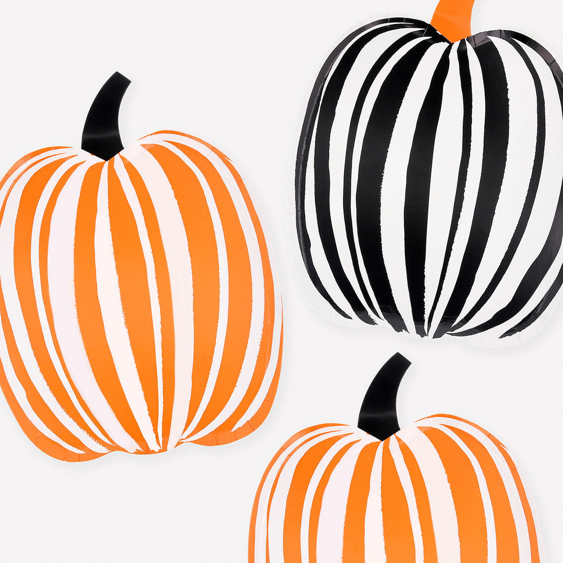 Three pumpkins shaped paper plates with orange and white stripes, black and white stripes, and orange and black stripes on a white background.