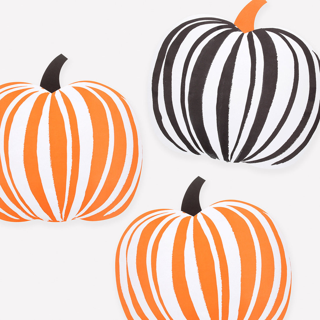 Three paper pumpkin shaped placemats with black and orange stripes on a white background
