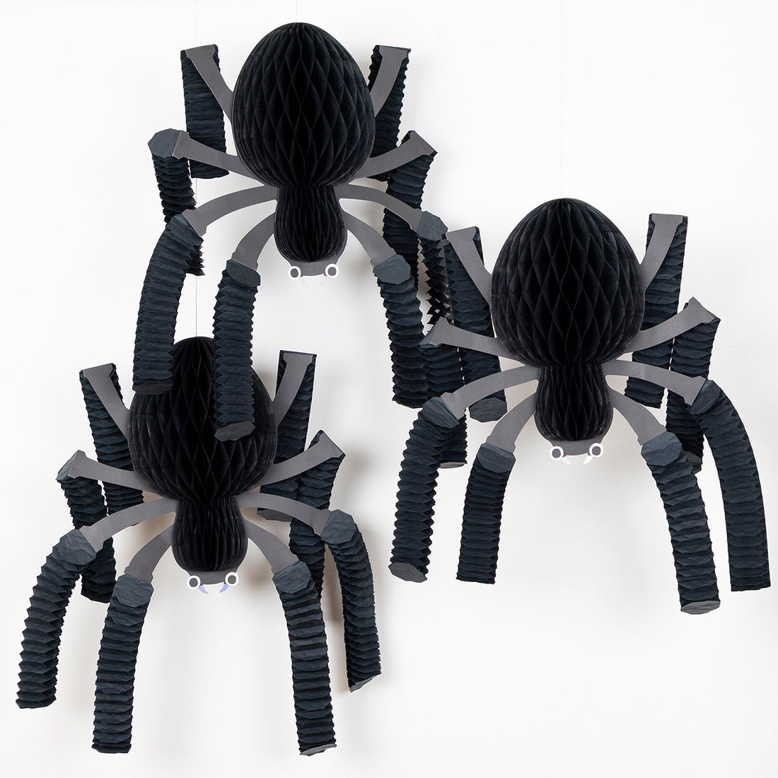 Three black and gray spider decorations on a white background.