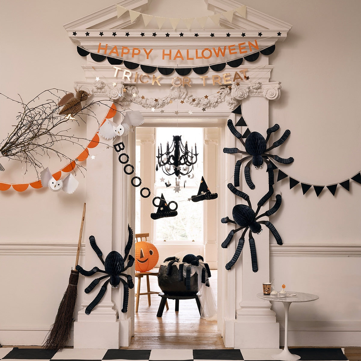 Halloween decorations including spiders, a broom, and &