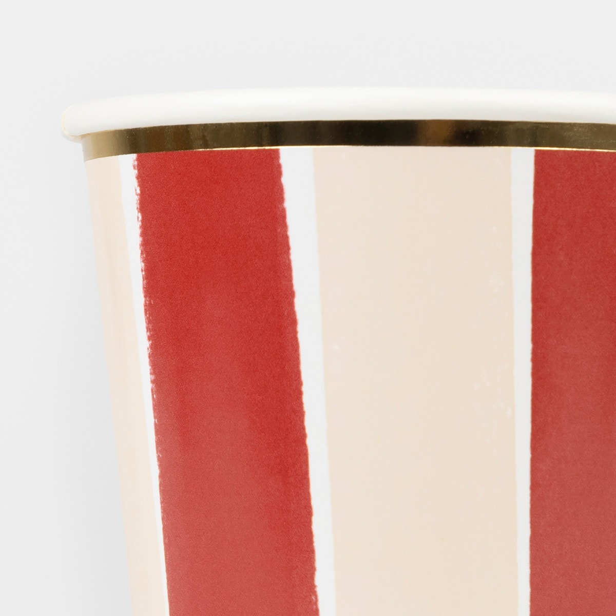 Close-up of a paper cup with red and white stripes on a white background.