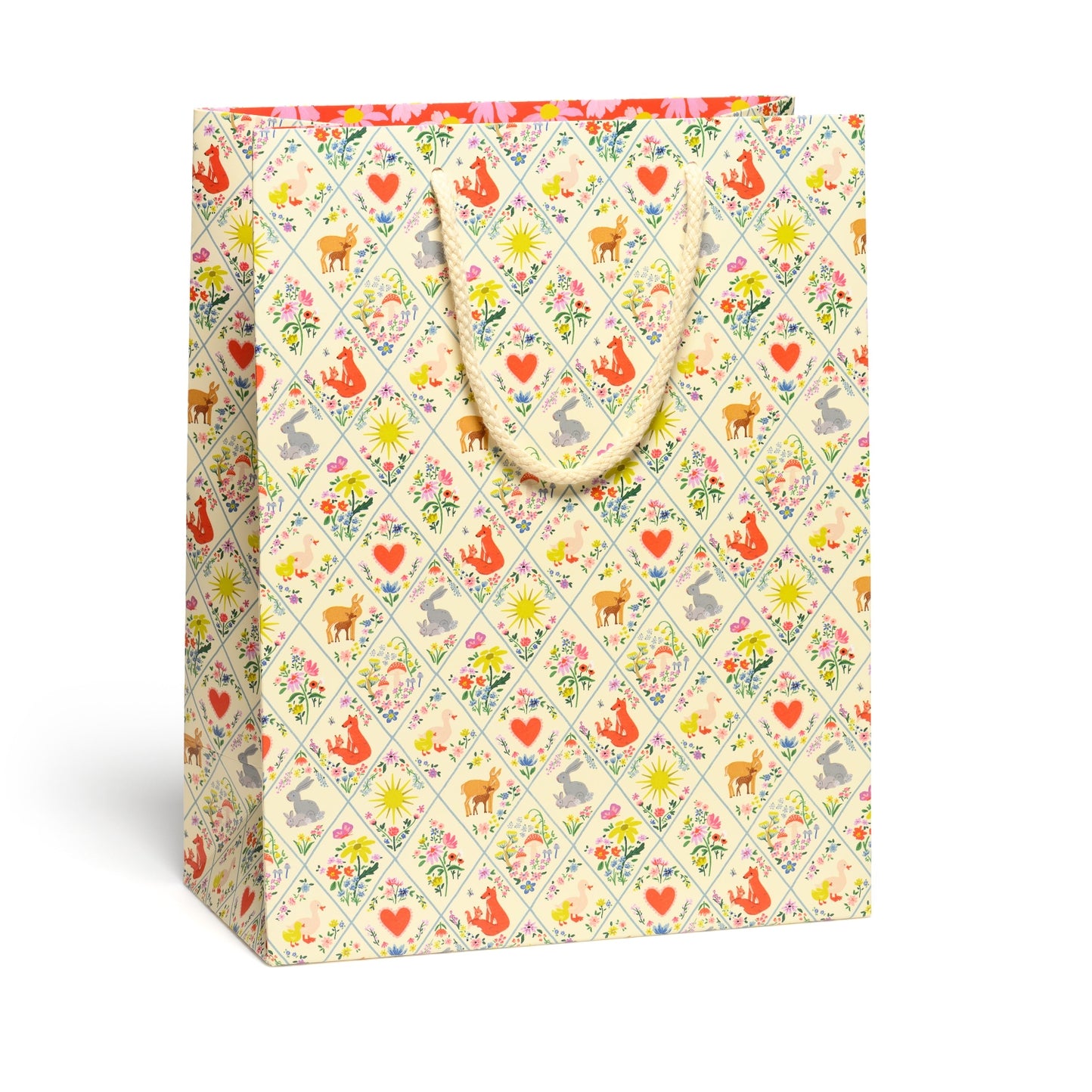 Gift bag with a colorful pattern of animals and flowers on a white background.