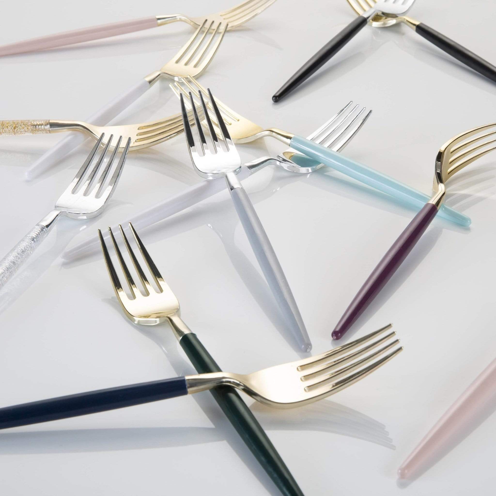 Set of colorful forks on a light gray background.