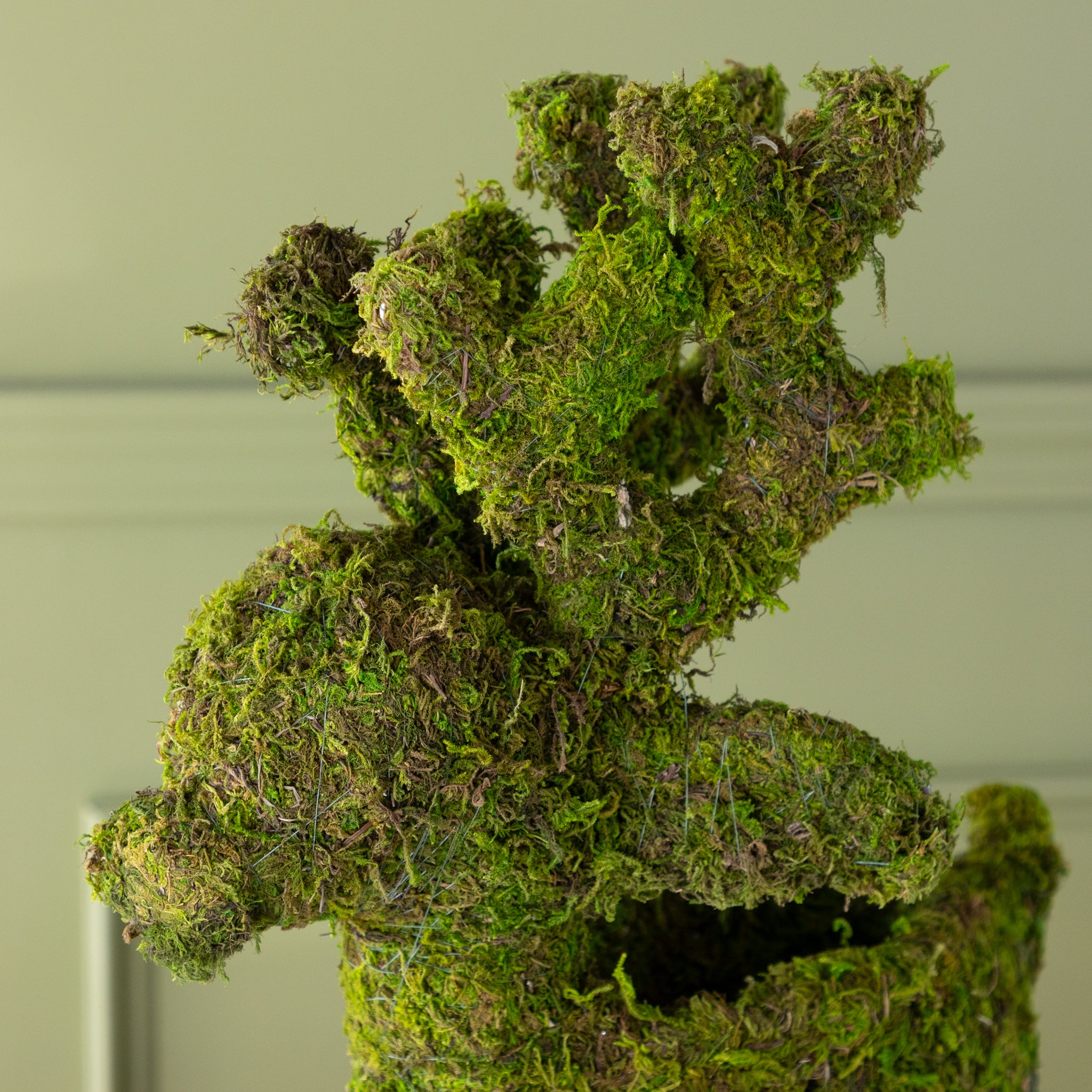 Close up of a moss-covered deer planter&