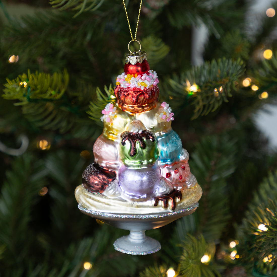 Glass Sundae Ornament hanging on a lit Christmas tree.