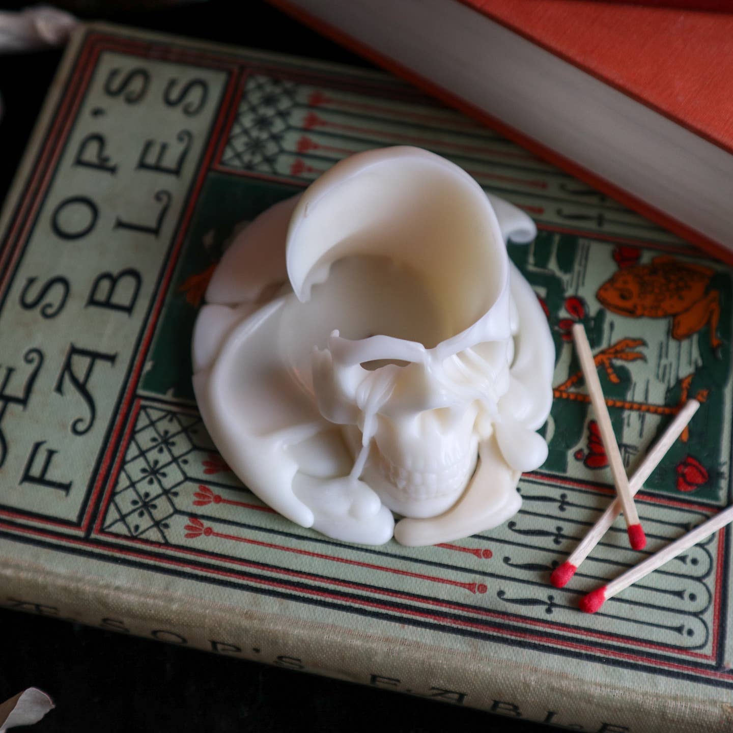 Cream skull shaped candle burning. 