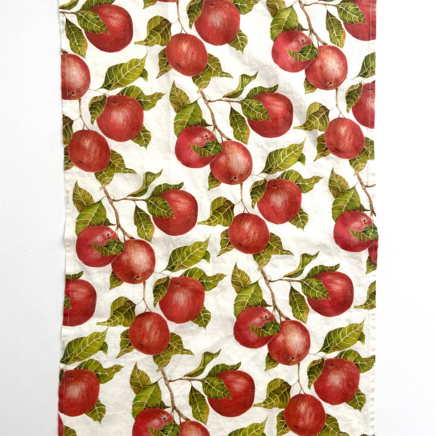 Pattern of red apples and green leaves on a white background