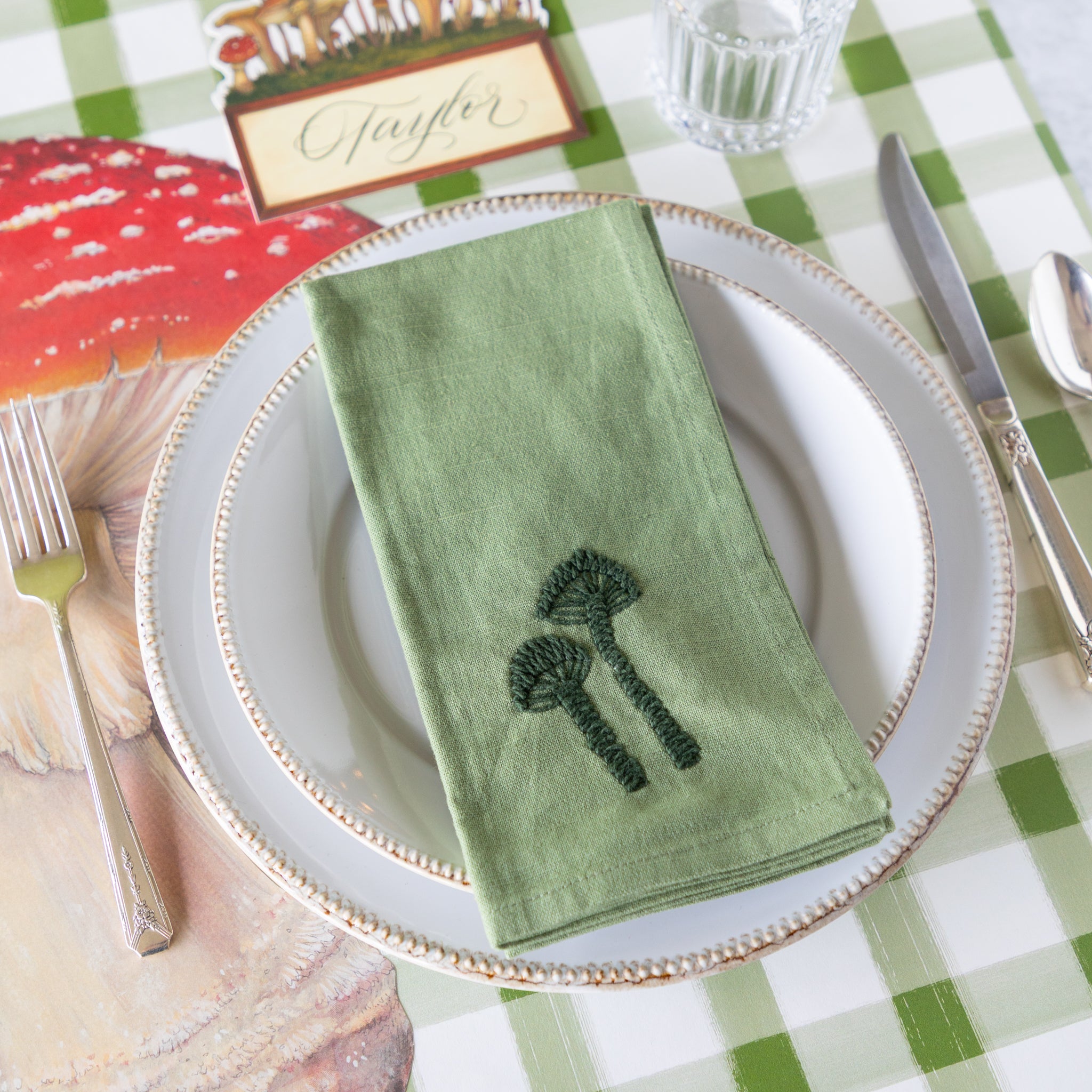 Mushroom-themed place setting with the Embroidered Mushroom Napkin resting on the plates.