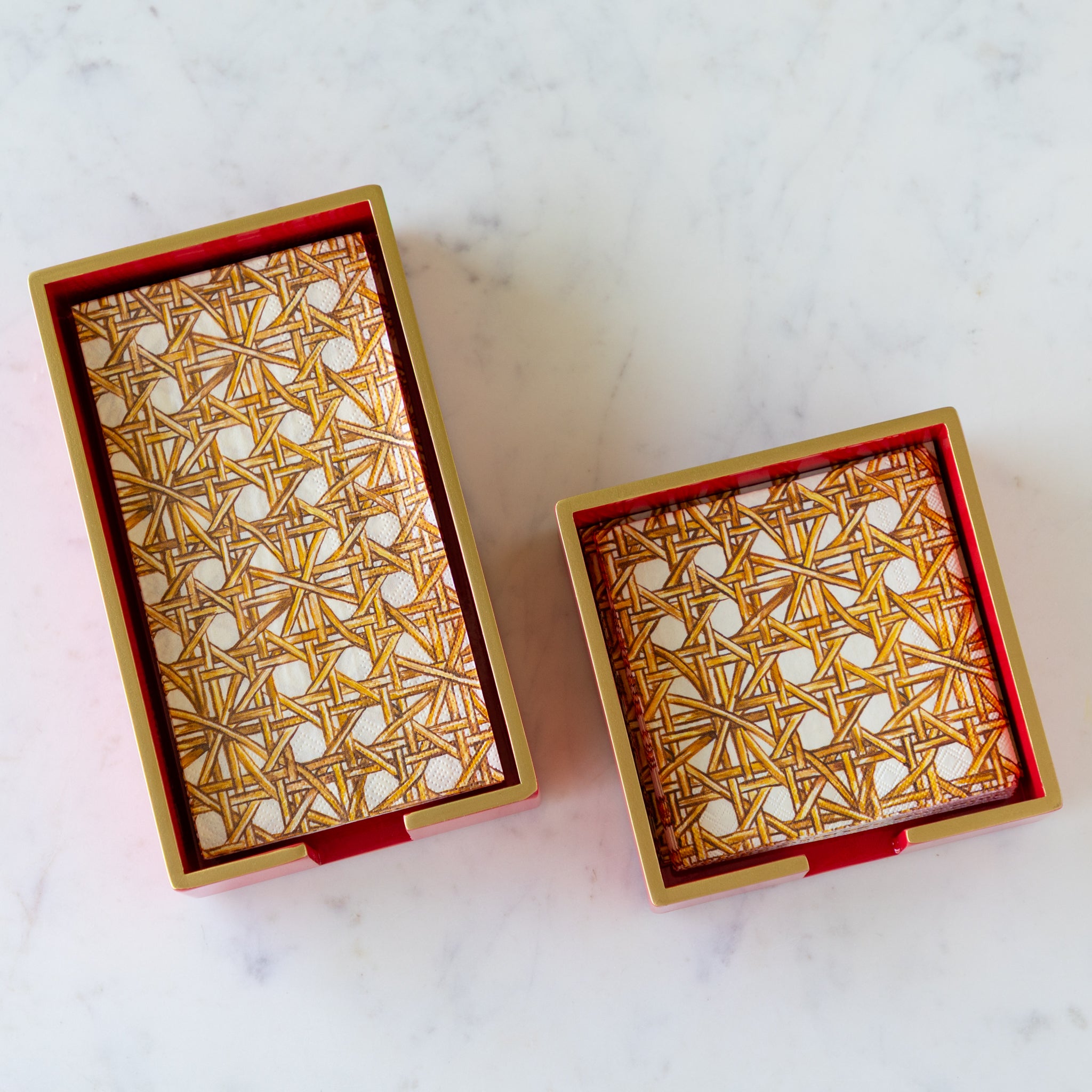Two Beverage Napkin Holders in red with gold trim holding Rattan Weave Napkins.