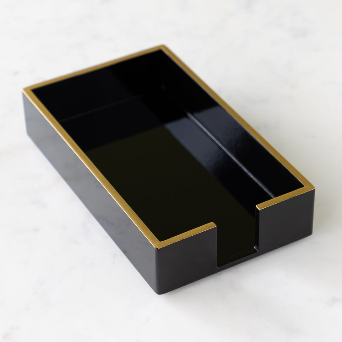Black Guest Towel Napkin Holder with Gold Trim on a marble table.