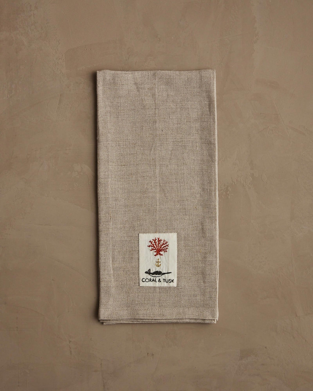 Textured napkin with a logo on a beige background