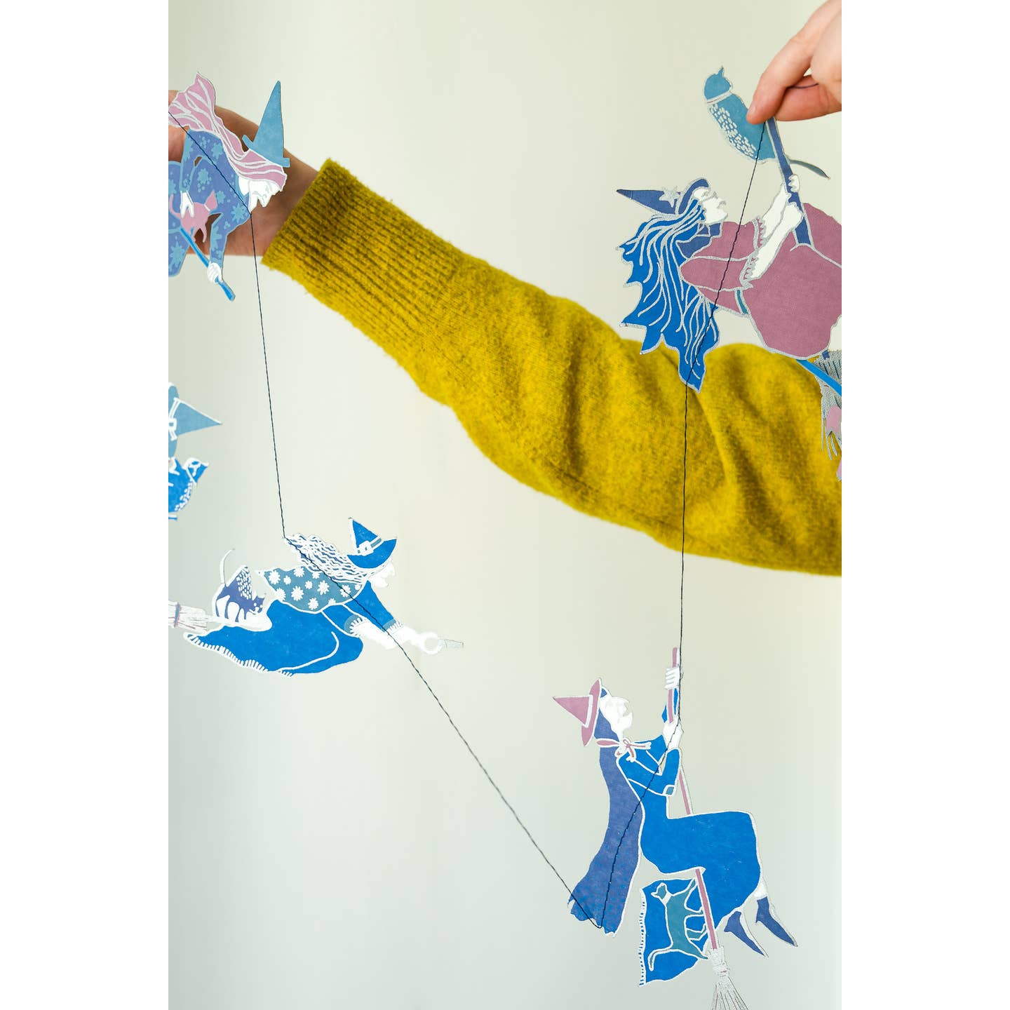 Person holding the witches garland.