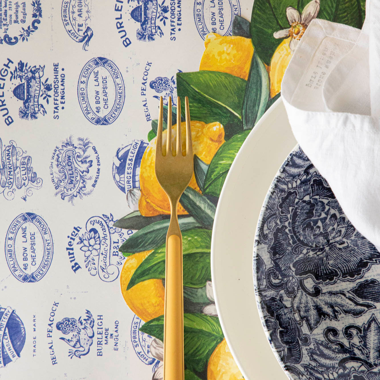 Burleigh Heritage Runner under the Die-cut Lemon Wreath Placemat with an elegant place setting  on top.