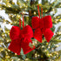 Red velvet bows hanging on a decorated Christmas tree.