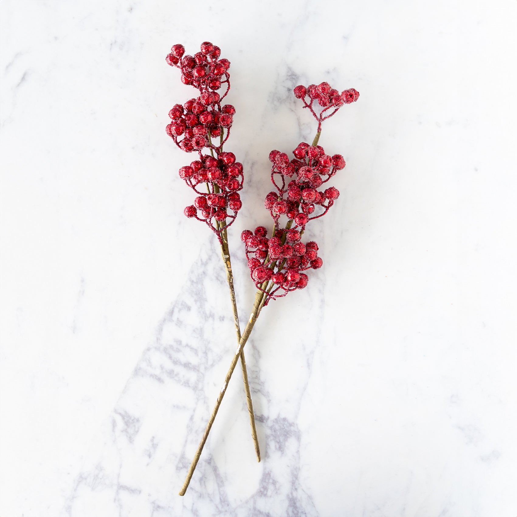 Two Red Cranberry Red Iced Picks  on a marble surface.