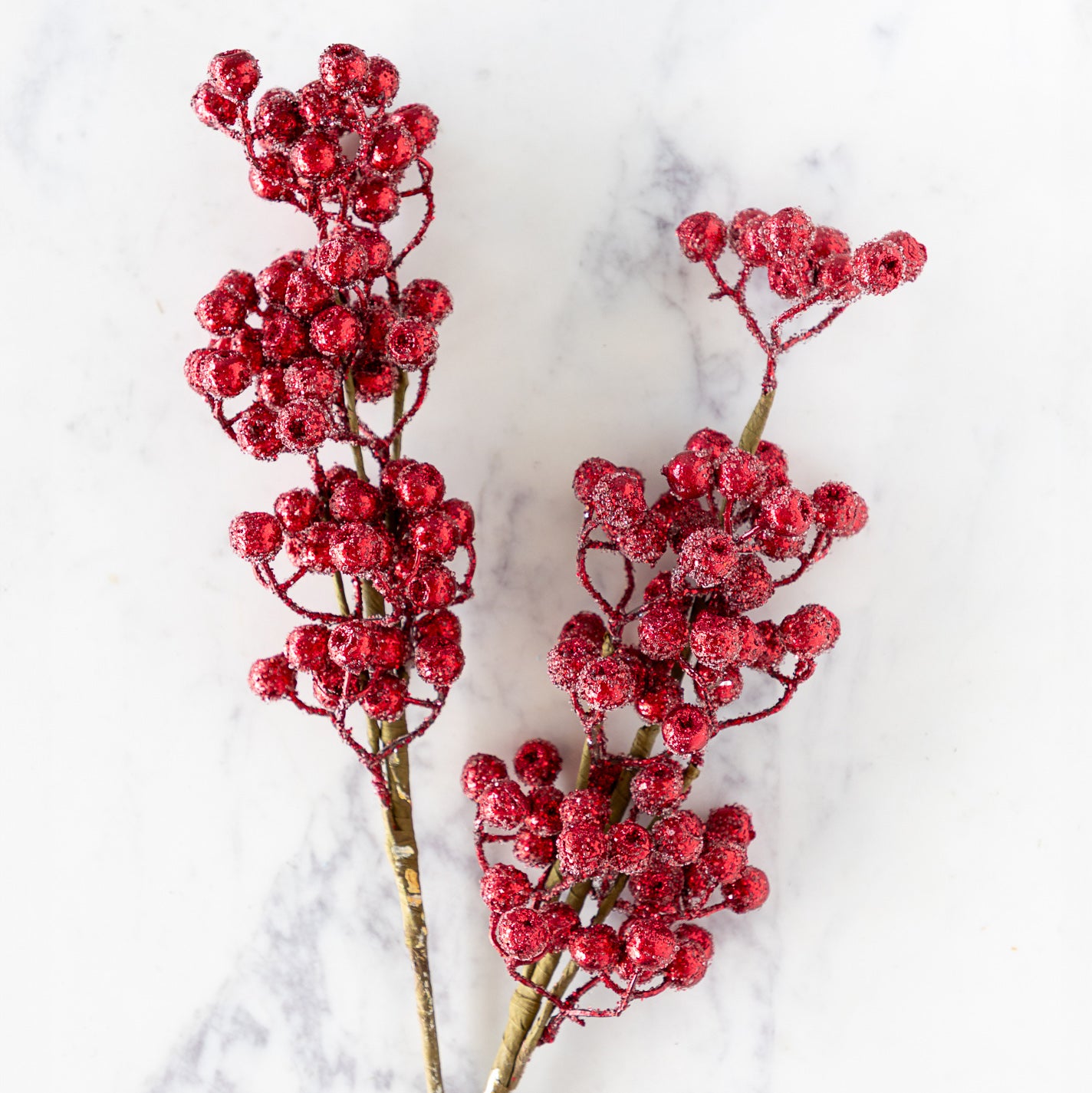 Two Red Cranberry Red Iced Picks  on a marble surface.