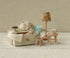 Miniature tea set with mouse and lamp in a room with patterned wallpaper.