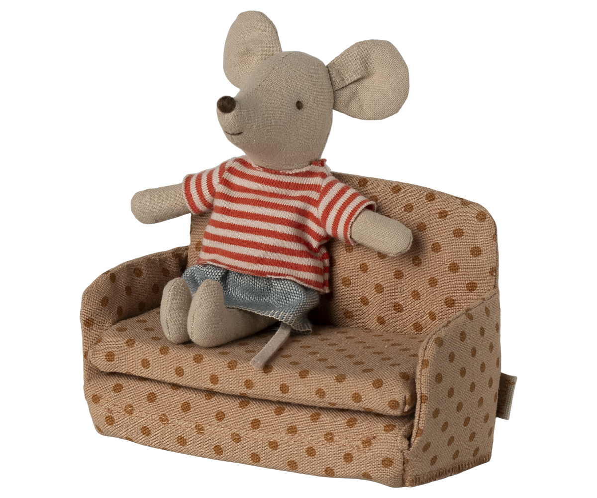 Stuffed mouse toy in a striped shirt sitting on a polka dot couch with a white background.
