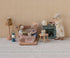 Miniature scene with toy mice and furniture against a striped wall.
