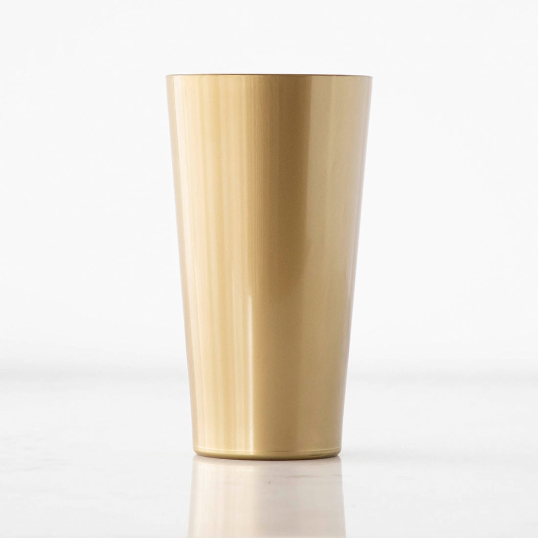 A single gold-colored, durable tumbler glass made from polymer material, displayed against a white background.