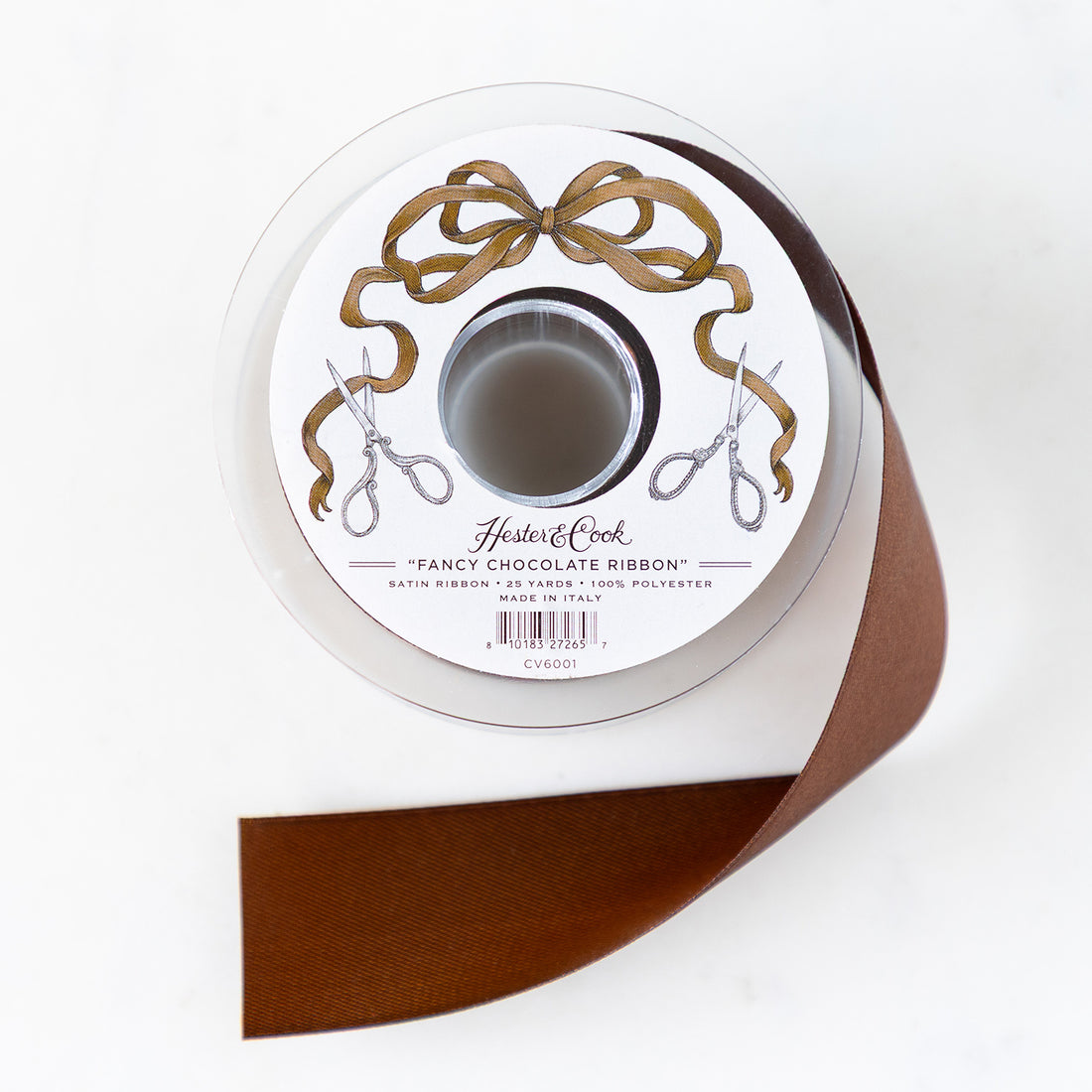 A spool of chocolate-brown satin ribbon with a label featuring illustrated scissors and brown bow branded &quot;Hester &amp; Cook Fancy Chocolate Ribbon.