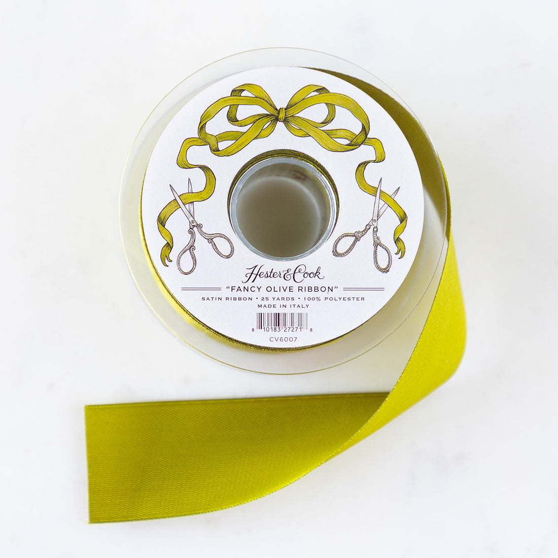 A spool of olive-green satin ribbon with a label featuring illustrated scissors and olive bow branded &quot;Hester &amp; Cook Fancy Olive Ribbon.
