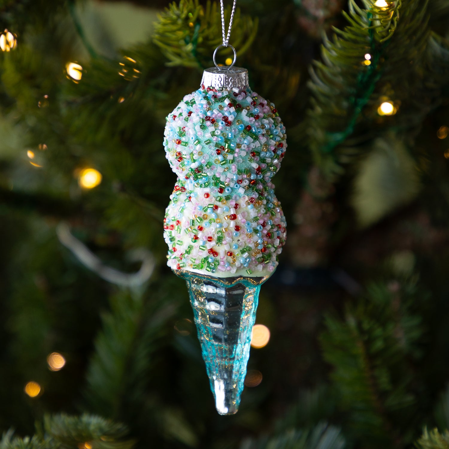 Decorative blue ice cream cone ornament on a Christmas tree.
