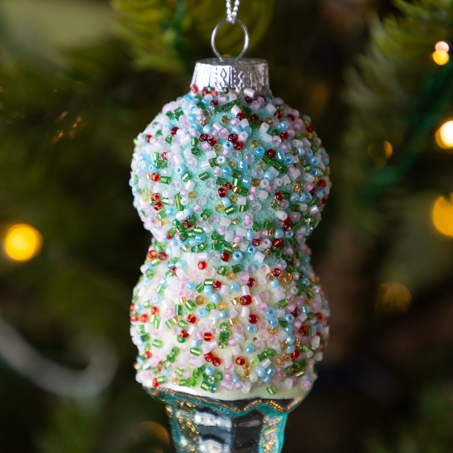 A close up of the Ice Cream Cone Ornament showing colorful beads and glitter over a blue and white fake scoop of ice cream.