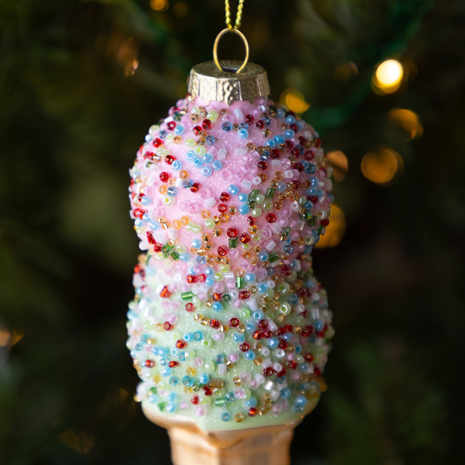 A close up of the Ice Cream Cone Ornament showing colorful beads and glitter over a pink and green fake scoop of ice cream.