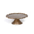 Decorative cake stand with scalloped edge and gold finish on a white background.