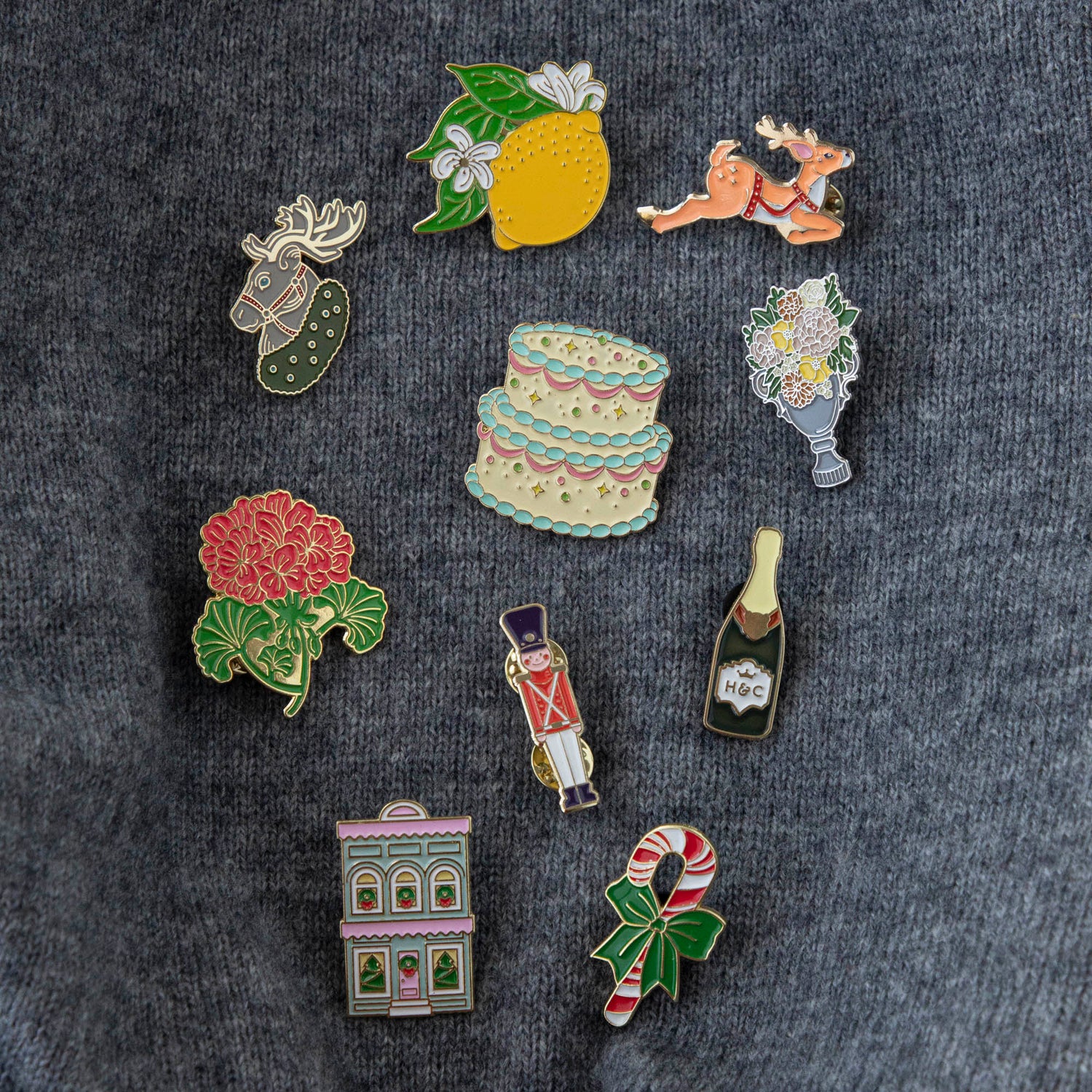 A Hester &amp; Cook Birthday Cake Enamel Pin on a marble surface.