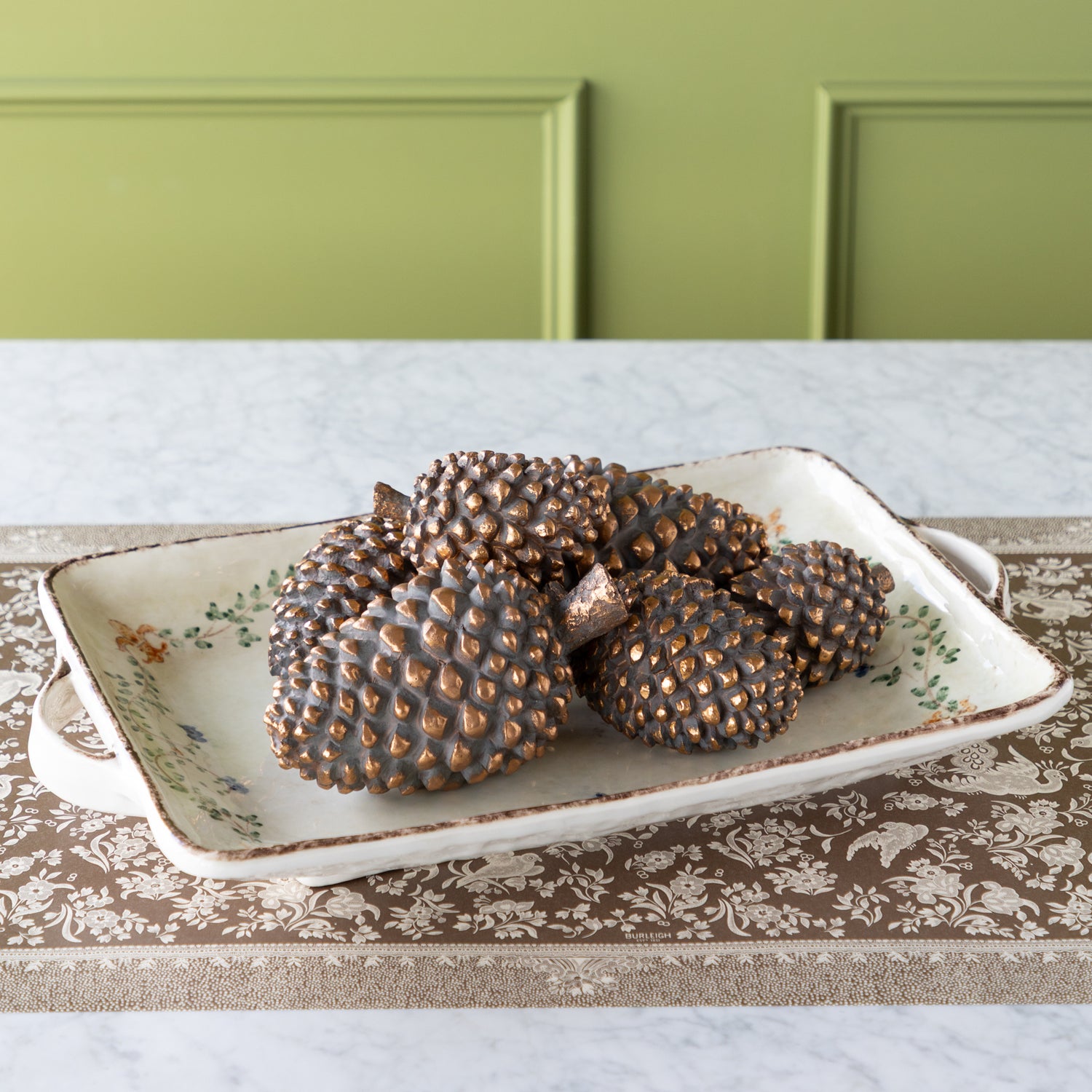 Decorative tray with bronze pinecones on the Brown Regal Peacock Runner.