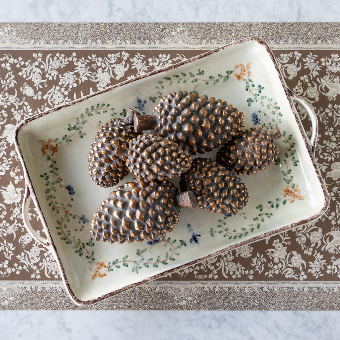 Decorative tray with bronze pinecones on the Brown Regal Peacock Runner.
