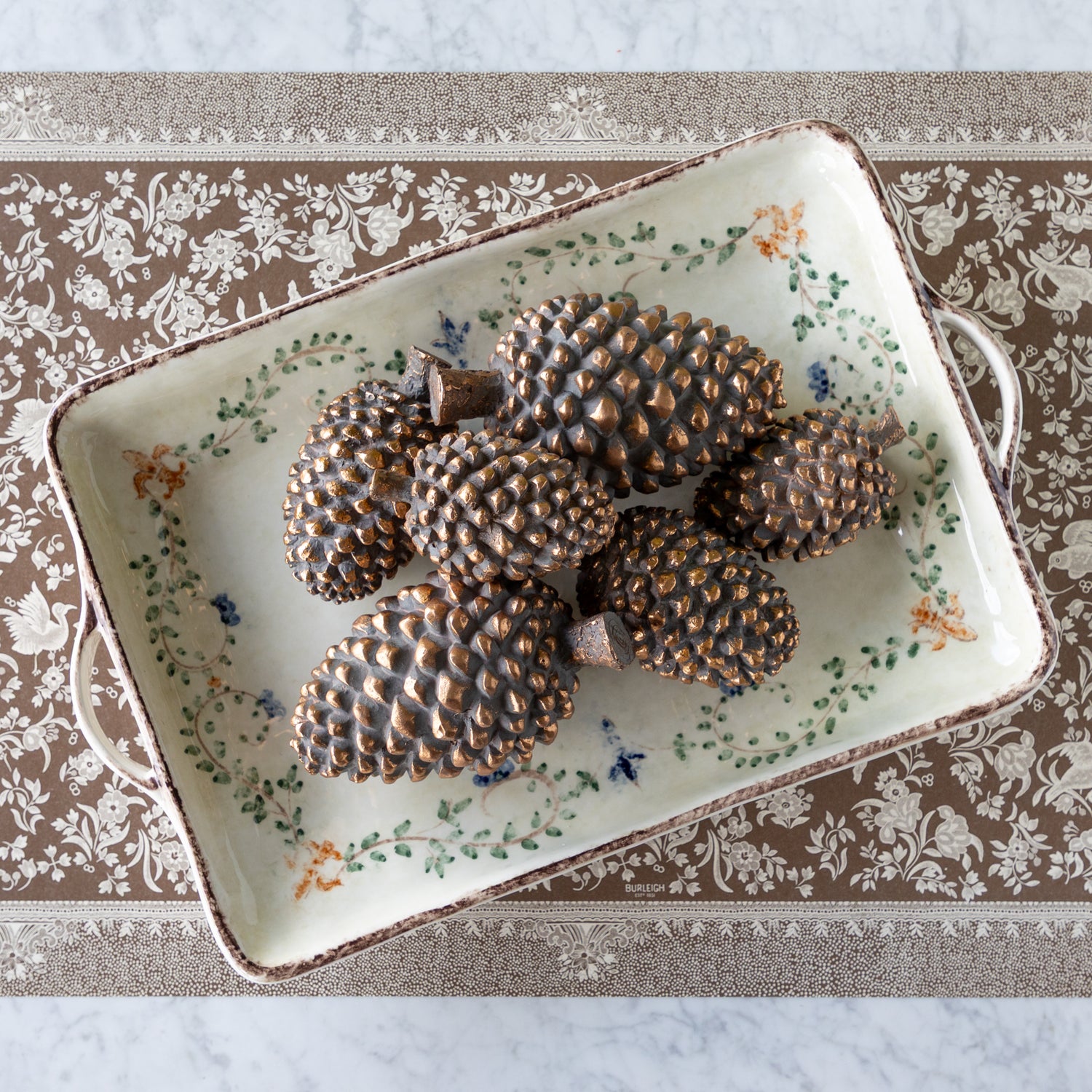 Decorative tray with bronze pinecones on the Brown Regal Peacock Runner.