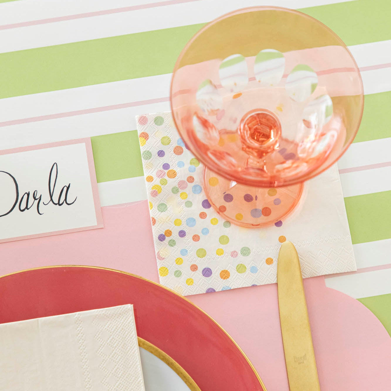 Confetti Sprinkles Cocktail Napkin under an empty glass on a place setting.