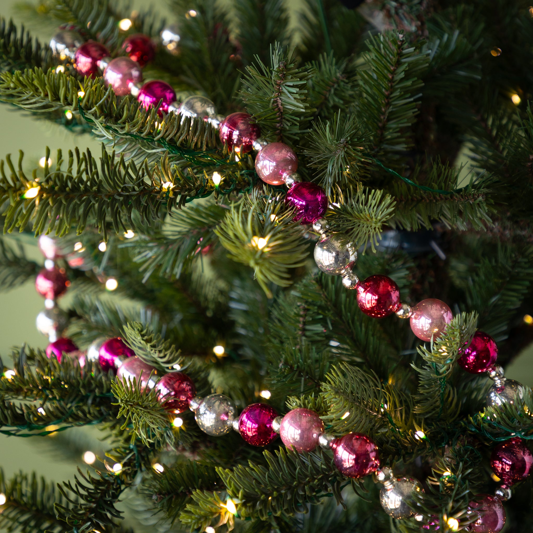 Pink & Silver Vintage Ornament Garland on a lit Christmas tree.