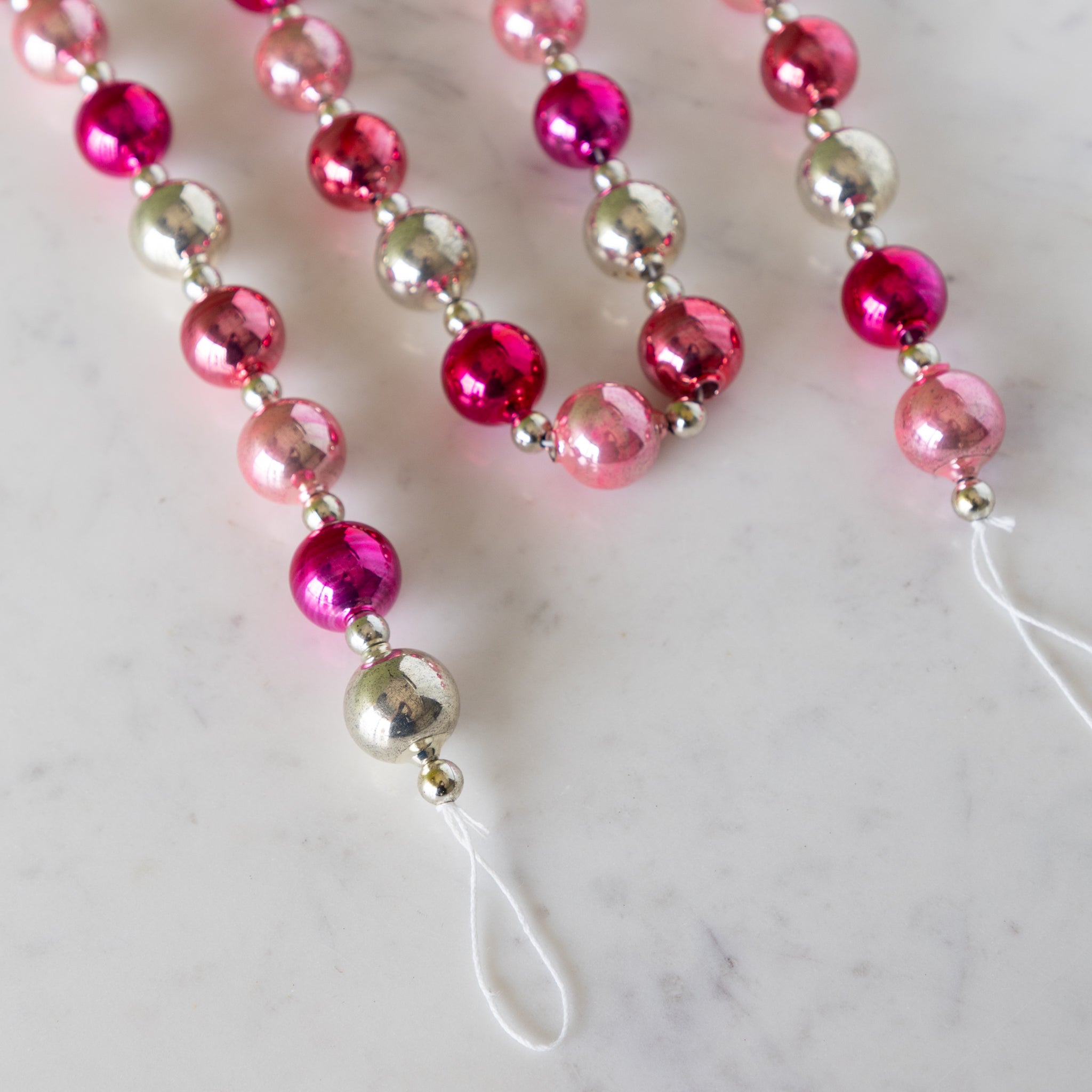 Pink & Silver Vintage Ornament Garland on a marble table.